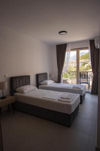 two beds in a room with a window at Vertmont Villa in Sveti Stefan