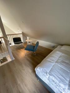 a bedroom with a bed and a chair and a staircase at Rocklunda Village in Västerås