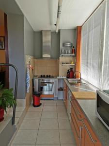 eine Küche mit Küchengeräten aus Edelstahl und Holzschränken in der Unterkunft Le coteau fleuri in Carnoux