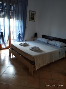 1 dormitorio con 1 cama grande y toallas. en L'oasi di Alice, en Sermoneta