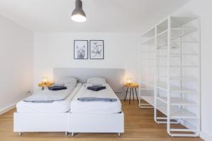 - une chambre avec 2 lits et une étagère dans l'établissement Glück Auf Appartements Walter-Hohmann-Straße Essen, à Essen