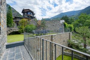 ein Haus mit einer Steinmauer und einem Balkon in der Unterkunft Quiet House Sa Calma in Andorra la Vella