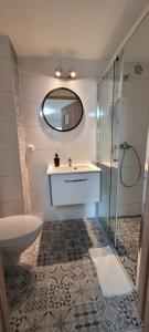 La salle de bains est pourvue de toilettes, d'un lavabo et d'un miroir. dans l'établissement Willa Maja, à Jastrzębia Góra