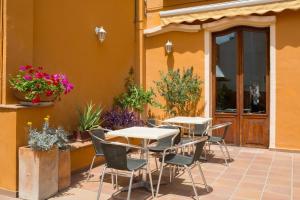 un patio con mesas y sillas frente a un edificio en L'Agora Hotel, en Bocairent