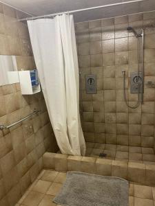 a bathroom with a shower with a shower curtain at Kunst- und Naturfreundehaus Brünig in Lungern