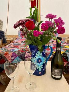 una mesa con una botella de vino y un jarrón de flores en Noddfa Farm Guest House, en Haverfordwest