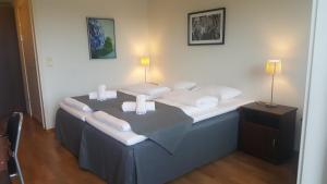Habitación con cama con almohadas blancas. en Motell Svinesundparken, en Halden