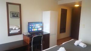 a hotel room with a television and a desk with a mirror at Motell Svinesundparken in Halden