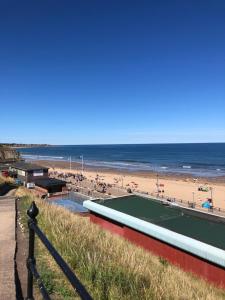 einen Strand mit Tennisplatz und das Meer in der Unterkunft Roker Cottage, luxury seaside apartment, private parking, sky tv in Sunderland