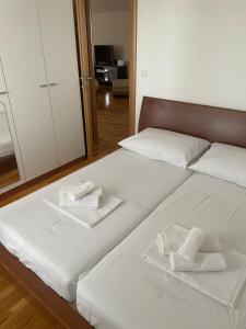 una camera con due letti con lenzuola e asciugamani bianchi di Villa Paludo a Novigrad (Cittanova)