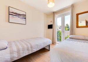 a bedroom with two beds and a window at Aadref in The Mumbles