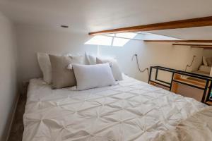 - un grand lit blanc avec des oreillers dans l'établissement Tinyc Joy, 