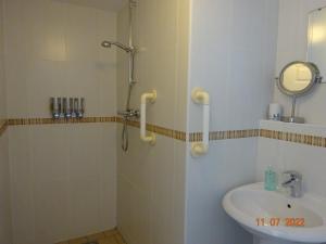 un baño con ducha y lavabo en Sterling Bed & Breakfast, en Llandudno 12 fotos más