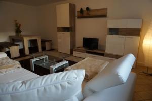 ein Wohnzimmer mit einem weißen Sofa und einem Tisch in der Unterkunft Apartment Germersheim in Germersheim