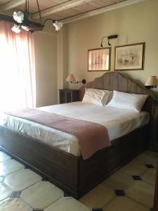 una camera con un grande letto con testiera in legno di Platamon sea view house a Platamonas