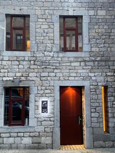 a brick building with a door and three windows at Au temps suspendu in Marche-en-Famenne