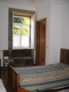 sypialnia z łóżkiem i oknem w obiekcie Vila Guiomar - Casa da Eira w mieście Alvarenga