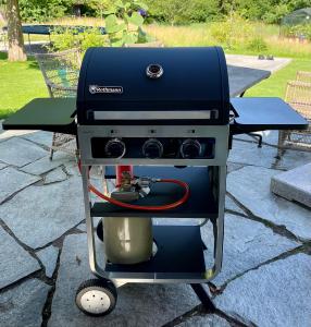 una parrilla sentada en un carro en un patio en Ferienhaus BERGEBLICK DELUXE en Bad Tölz