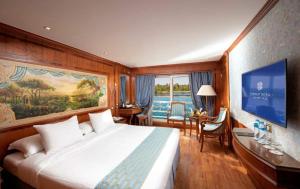 a hotel room with a large bed and a desk at Horus Eye Nile Cruse in Luxor
