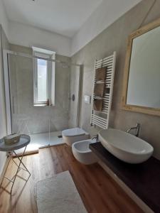 a bathroom with two toilets and a tub and a sink at Maison Gabrielle in Verona