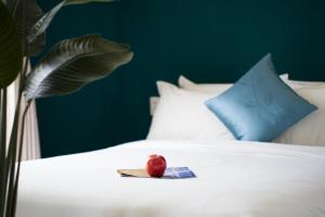a plate with an apple sitting on a bed at Merry Land Hotel Da Nang in Danang