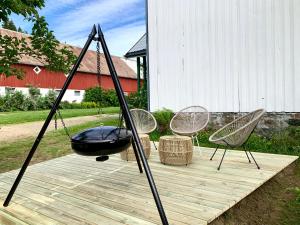 a swing and two chairs on a wooden deck at Landlig leilighet in Landsem