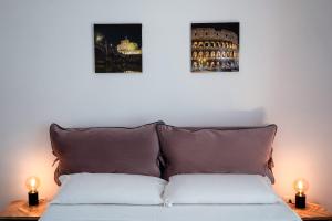 - un lit avec deux photos sur le mur au-dessus dans l'établissement Beatrix House, à Rome