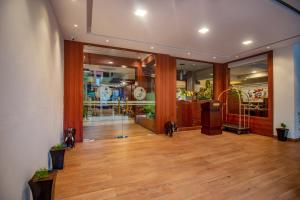 a large room with wooden floors and glass doors at Zip By Spree Hotels Mangala Towers Thrissur in Trichūr