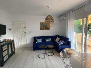 uma sala de estar com um sofá azul e uma mesa em Stil Port Mar Anna em L'Escala