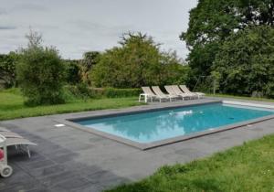 a swimming pool with two lounge chairs at Chateau De La Moriniere in Beaupréau