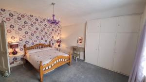 a bedroom with a wooden bed and a white cabinet at Cruden Villa - Second Floor Apartment in Scarborough