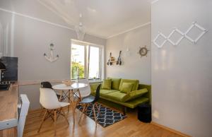 a living room with a green couch and a table at Apartament z widokiem na morze u Grażyny 3 in Jarosławiec