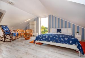 a bedroom with a blue and white bed and a chair at Apartament z widokiem na morze u Grażyny 3 in Jarosławiec