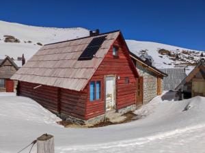 佛伊尼卡的住宿－Koliba Nazif Softić，雪上带太阳能屋顶的红色小屋