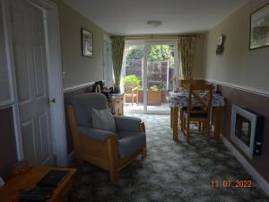 uma sala de estar com uma cadeira e uma mesa em Sterling Bed & Breakfast em Llandudno