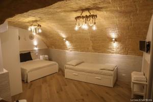 a bedroom with two beds and a brick wall at La casa di San Nicola in Bari