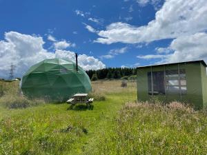 a tent and a picnic table in a field at Pant y Rhedyn Glamping and camping site in Abergele