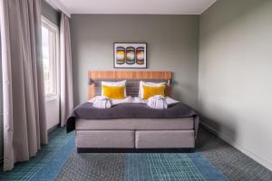 a bedroom with a large bed with yellow pillows at Quality Hotel Park Södertälje City in Södertälje