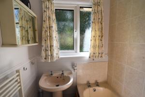 a bathroom with a sink and a toilet and a window at Mount View in Uplyme +15 photos
