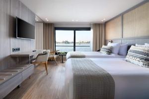 a hotel room with two beds and a desk at Horus Eye Nile Cruse in Luxor +24 photos