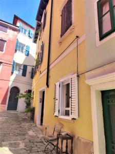 ein Gebäude mit einem Fenster und einer Bank auf einer Straße in der Unterkunft Apartment Mazza in Piran