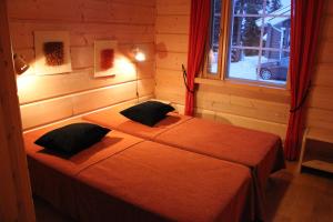 sypialnia z łóżkiem z 2 poduszkami i oknem w obiekcie Vuosselin Kruunu w mieście Ruka