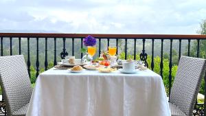 uma mesa branca com comida e bebidas numa varanda em Hotel Rural Playa de Aguilar em Muros de Nalón