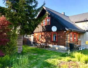 ein Holzhaus mit roten Fenstern und einem Hof in der Unterkunft Chata Górala Centralny Szczyrk in Szczyrk