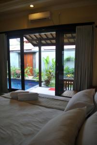 a bed with two pillows in a room with a window at Villa Sahabat in Gili Trawangan