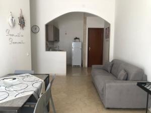 a living room with a couch and a table and a kitchen at Solemare Beach Apartment Trapani in Erice