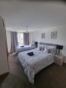 a bedroom with two beds and a large window at Dartford Lodge in Kent