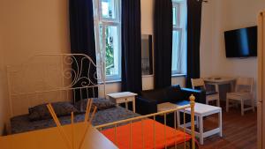 ソスノヴィエツにあるApartamenty przy STONEHENGEのベッドとリビングルームが備わる小さな客室です。