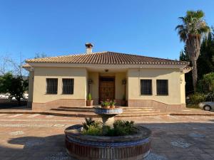 Una pequeña casa con una fuente delante de ella. en Villa Las Viñas, en Ronda