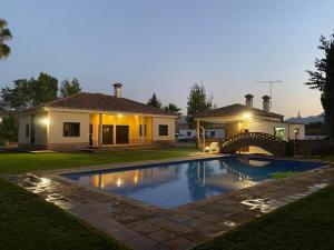 una casa con piscina delante de una casa en Villa Las Viñas, en Ronda